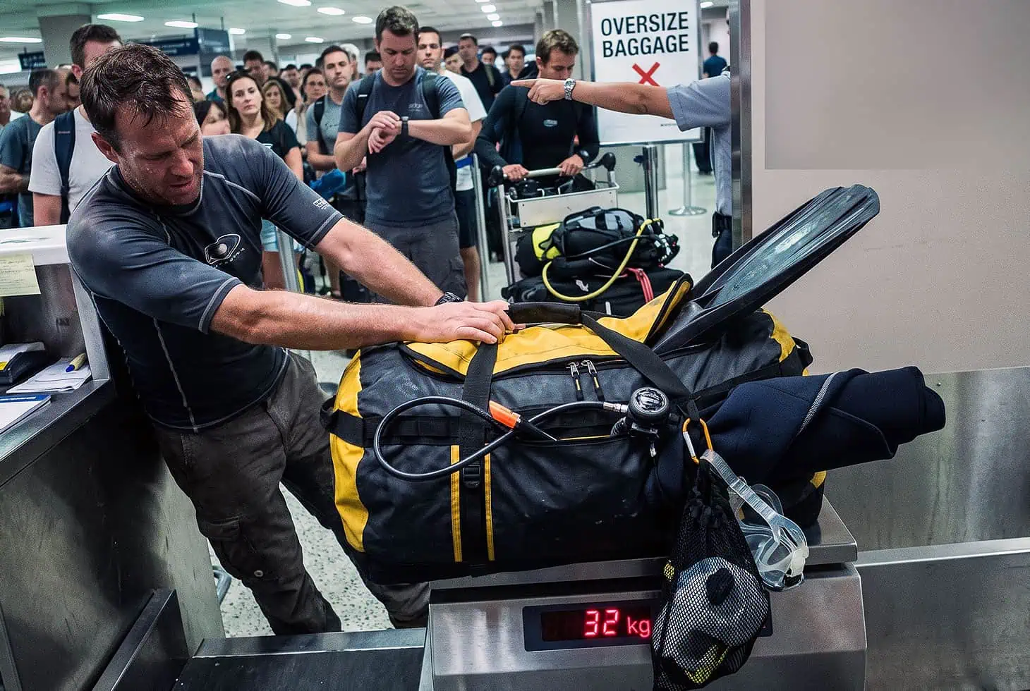 A dive bag on the scale of a check-in counter